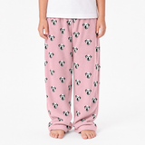 Pink pajama pants with dog pattern worn by a person on a white background