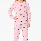 Child wearing pink jogger pajamas with dog pattern on a white background
