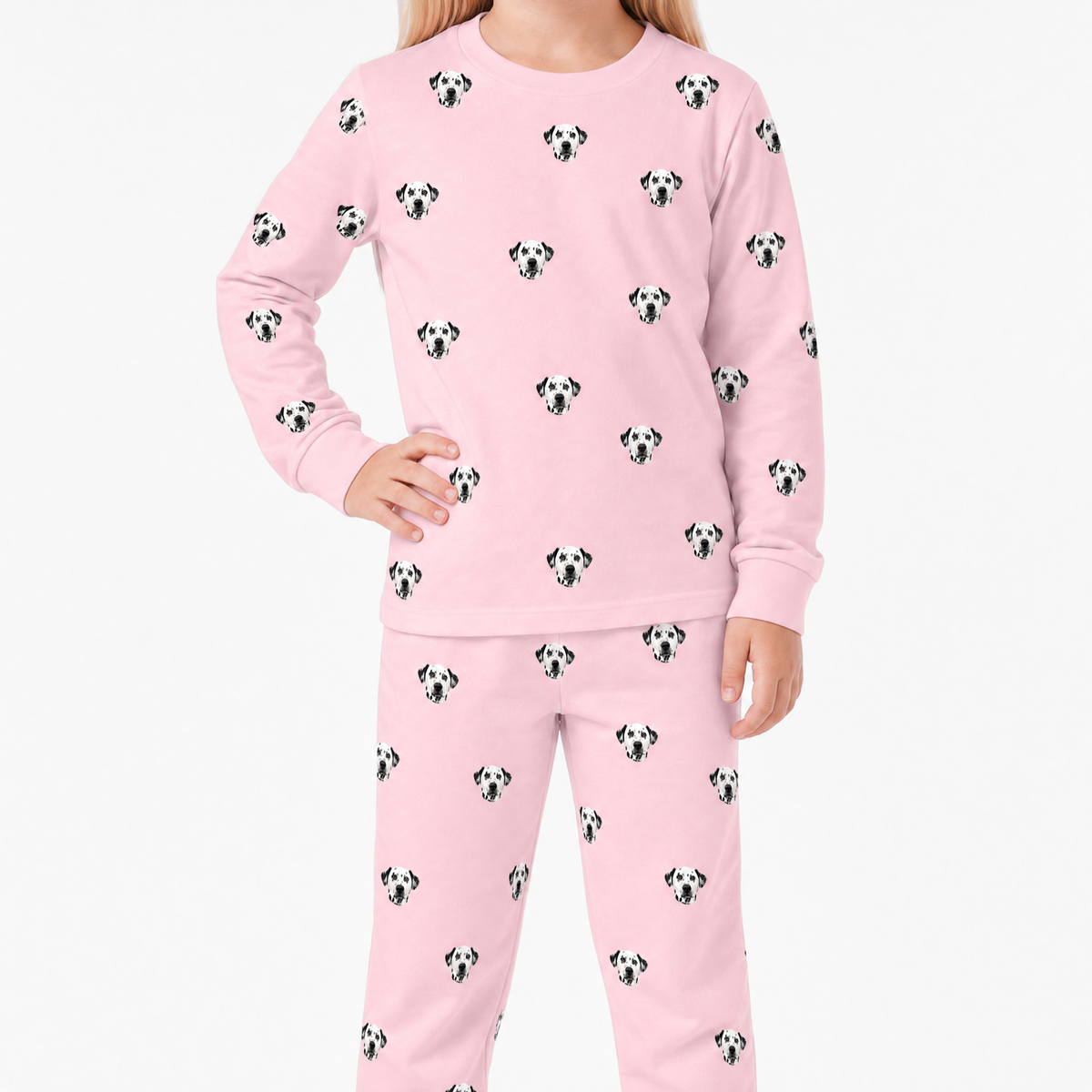 Child wearing pink jogger pajamas with dog pattern on a white background