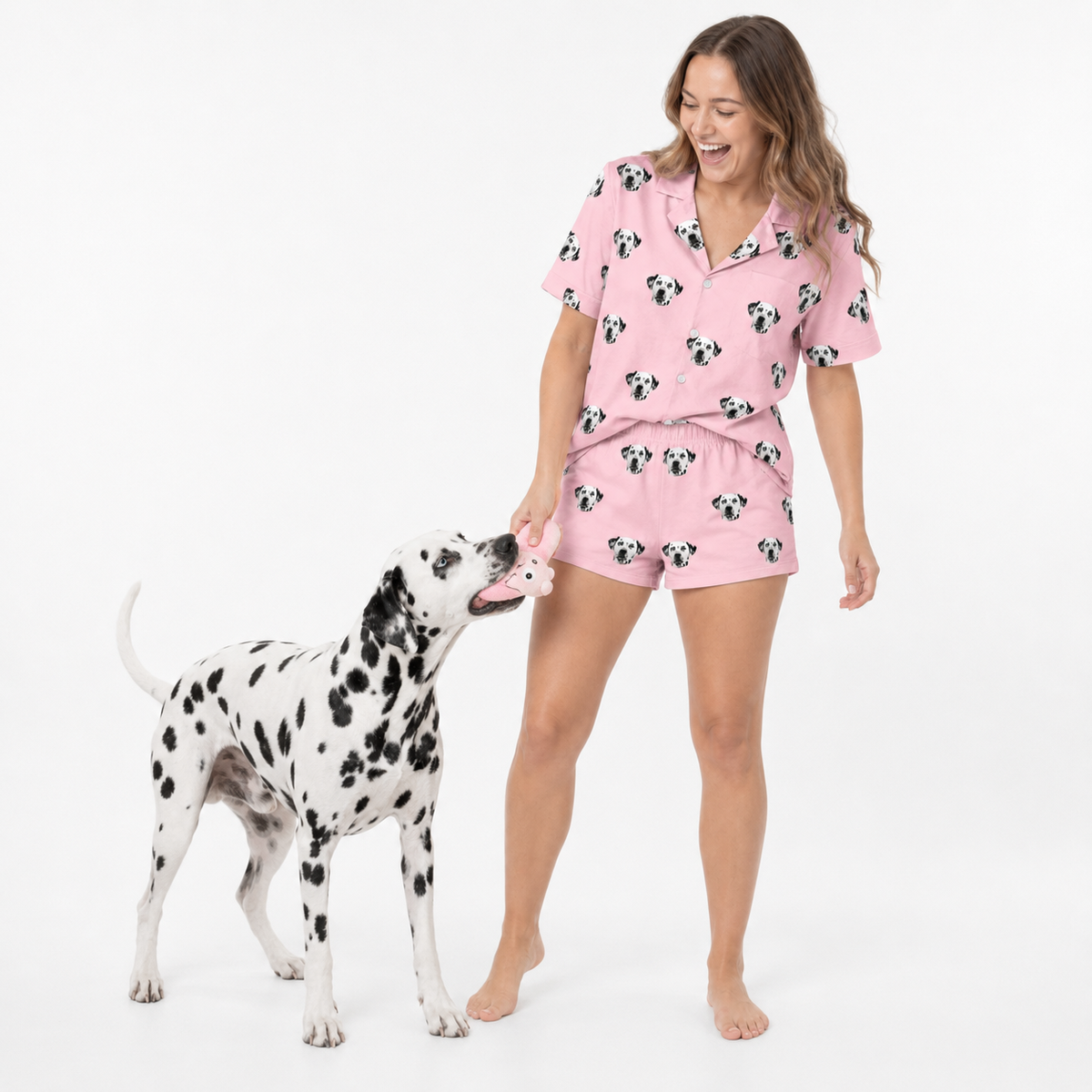 Woman in pink pajama set with dog on a white background