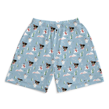 Light blue shorts with an all-over Christmas-themed print featuring Jack Russell Terriers, snowmen, pine trees, and snowflakes, displayed flat against a white background.