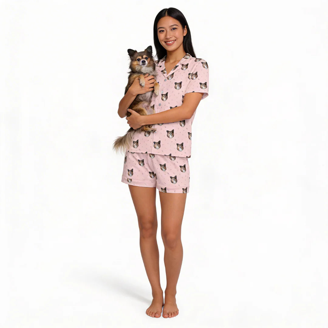 Woman wearing pink pajamas with dog print, holding a small dog, on a white background [BlushBlossoms