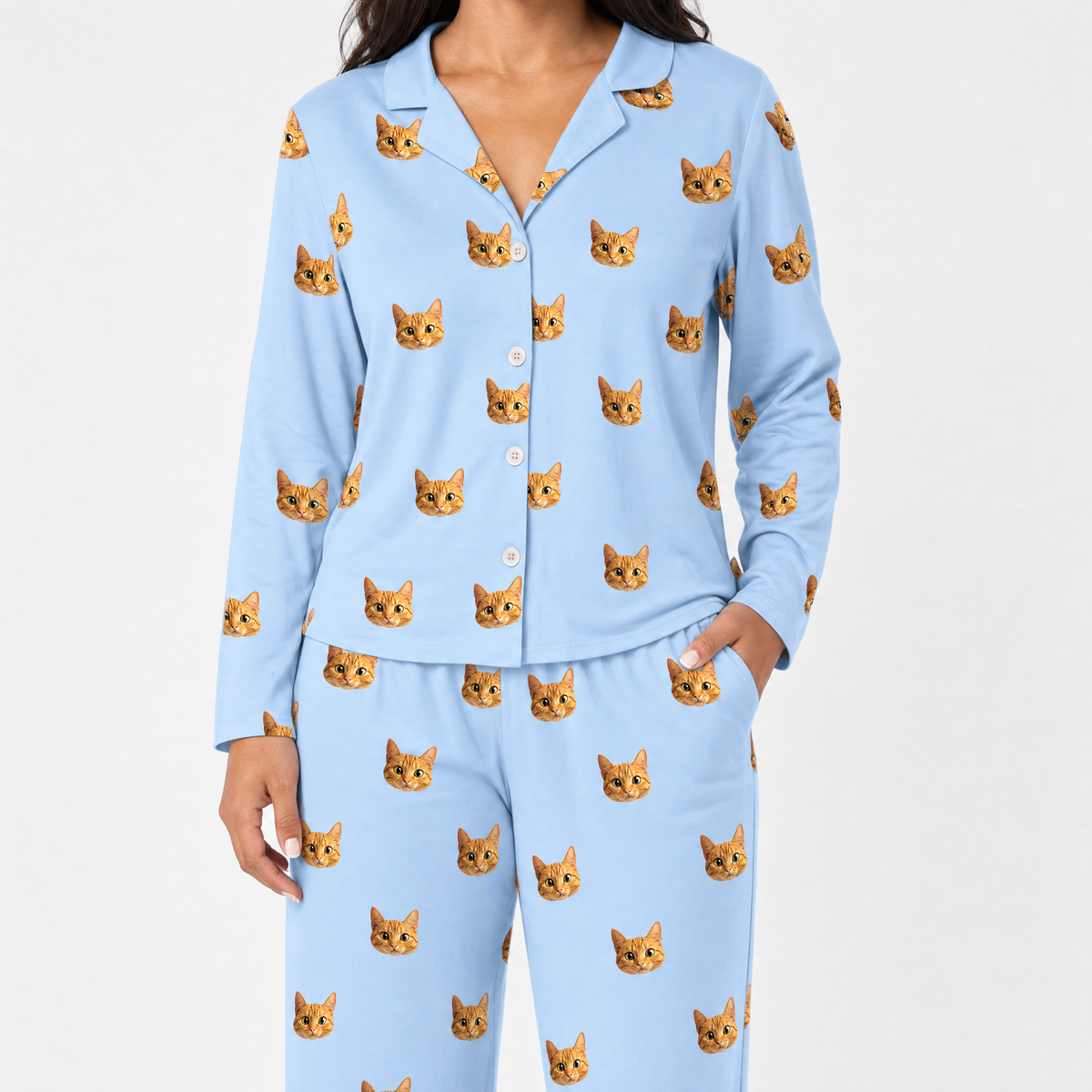 Sky blue pajama set with cat pattern worn by a person on a white background