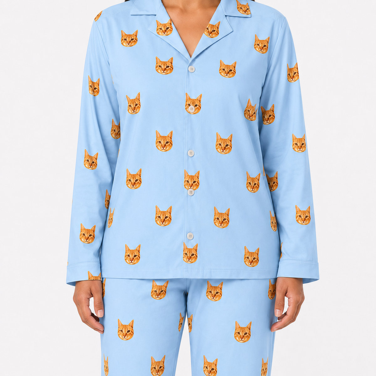 Sky blue pajama set with orange cat faces on a white background
