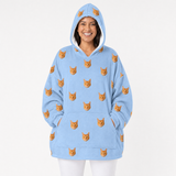 Person wearing a sky blue blanket hoodie with orange cat patterns on a white background