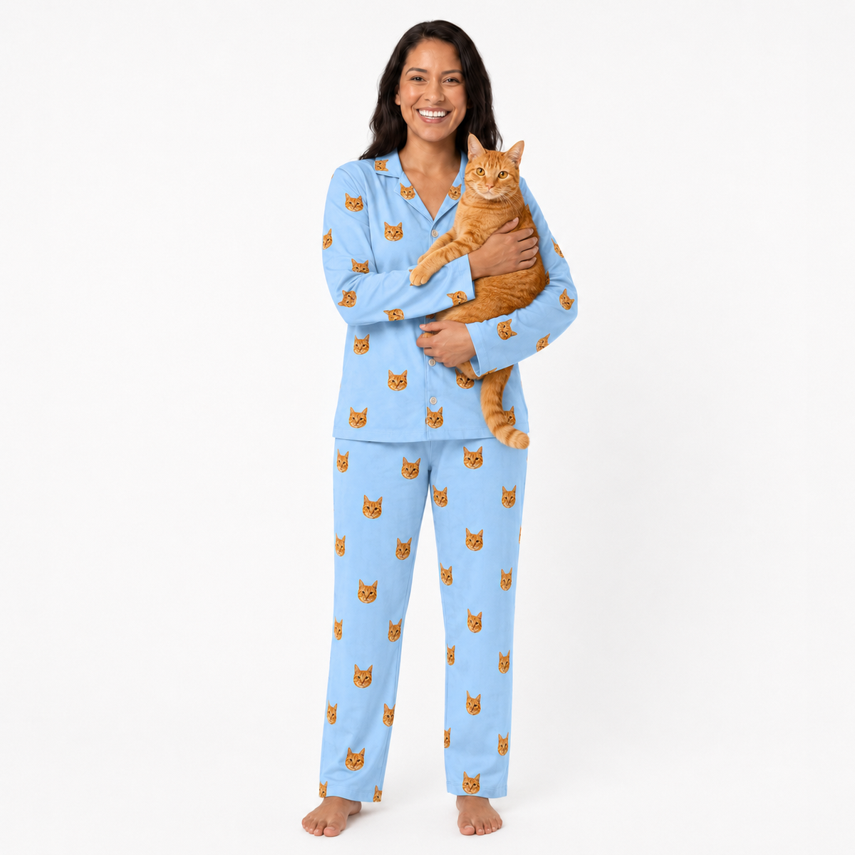 Woman wearing sky blue pajamas with cat pattern, holding an orange cat on a white background