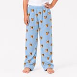 Sky blue pajama pants with dog pattern worn by a person on a white background