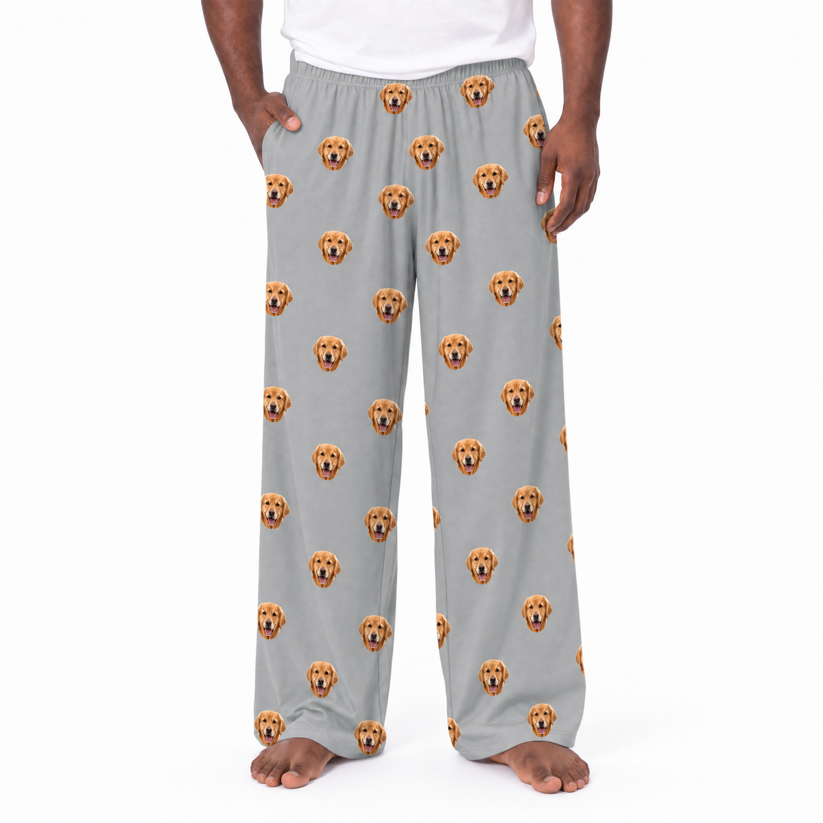 Gray pajama pants with dog face pattern worn by a person on a white background