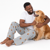 Slate gray adult pants theme – person in dog-print pajamas petting golden retriever.