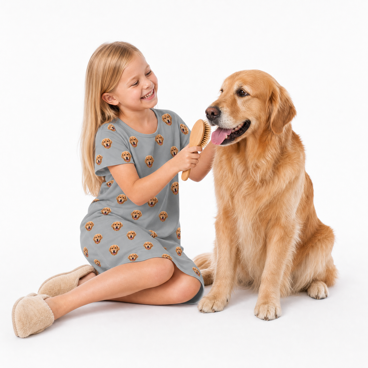 Young girl wearing nightgown brushing a dog with a comb on a white background