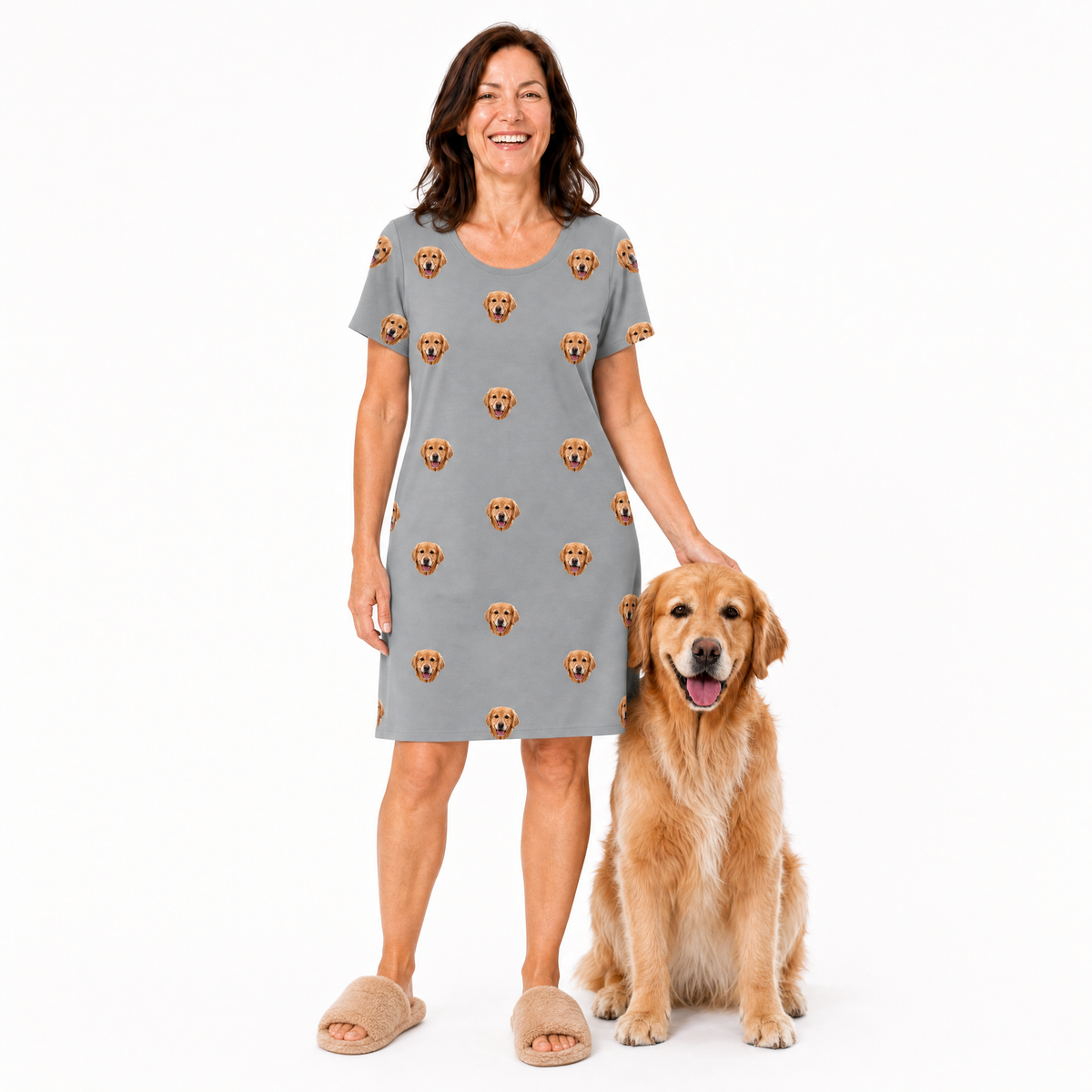 Woman wearing a gray nightgown with dog pattern standing next to a golden retriever on a white background