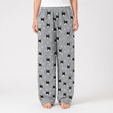 Gray pajama pants with black cat pattern worn by a person on a white background