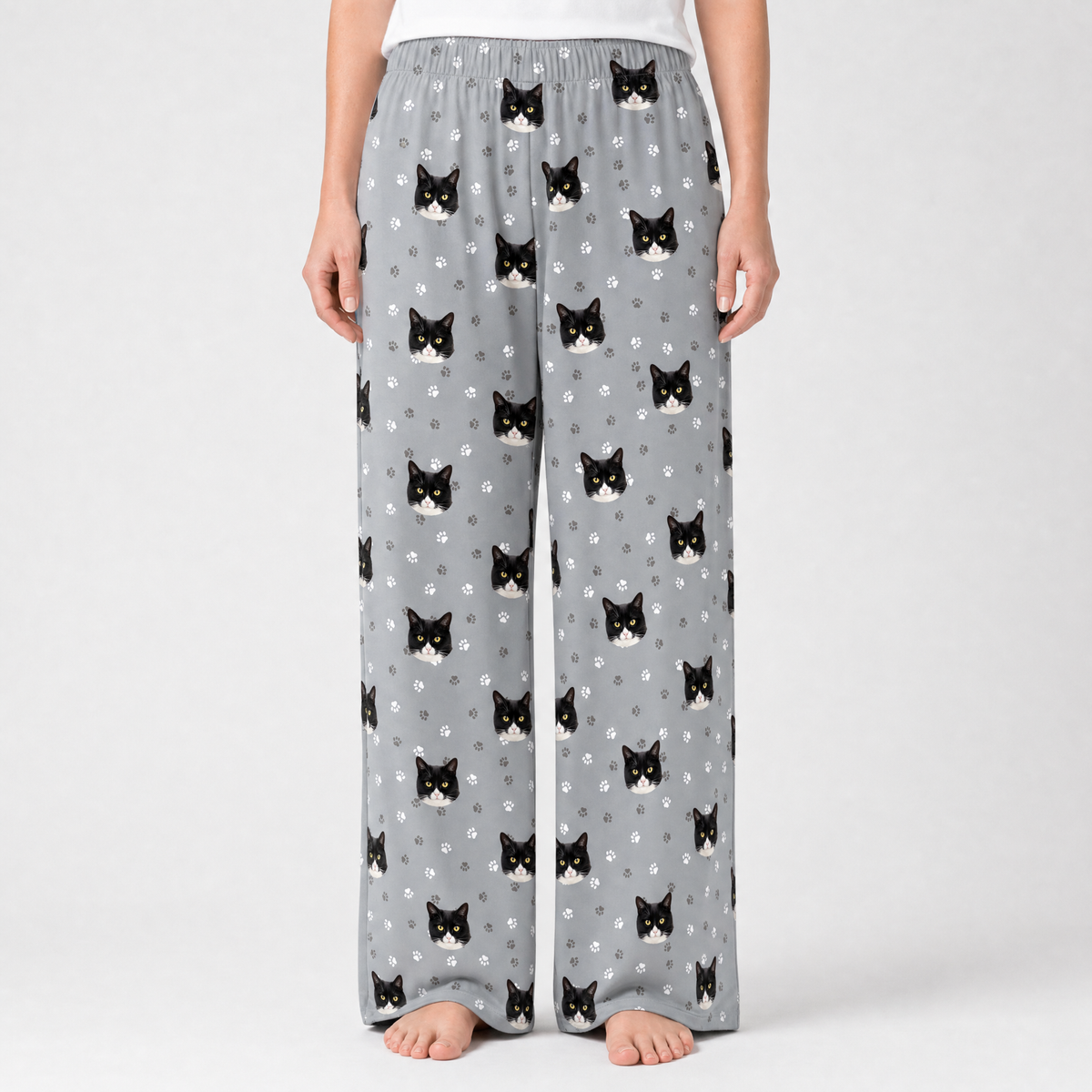 Gray pajama pants with black cat pattern on a white background