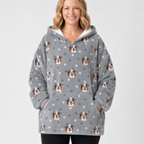 Person wearing a gray blanket hoodie with dog pattern on a white background