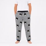 Person wearing gray pajama pants with black cat prints on a white background