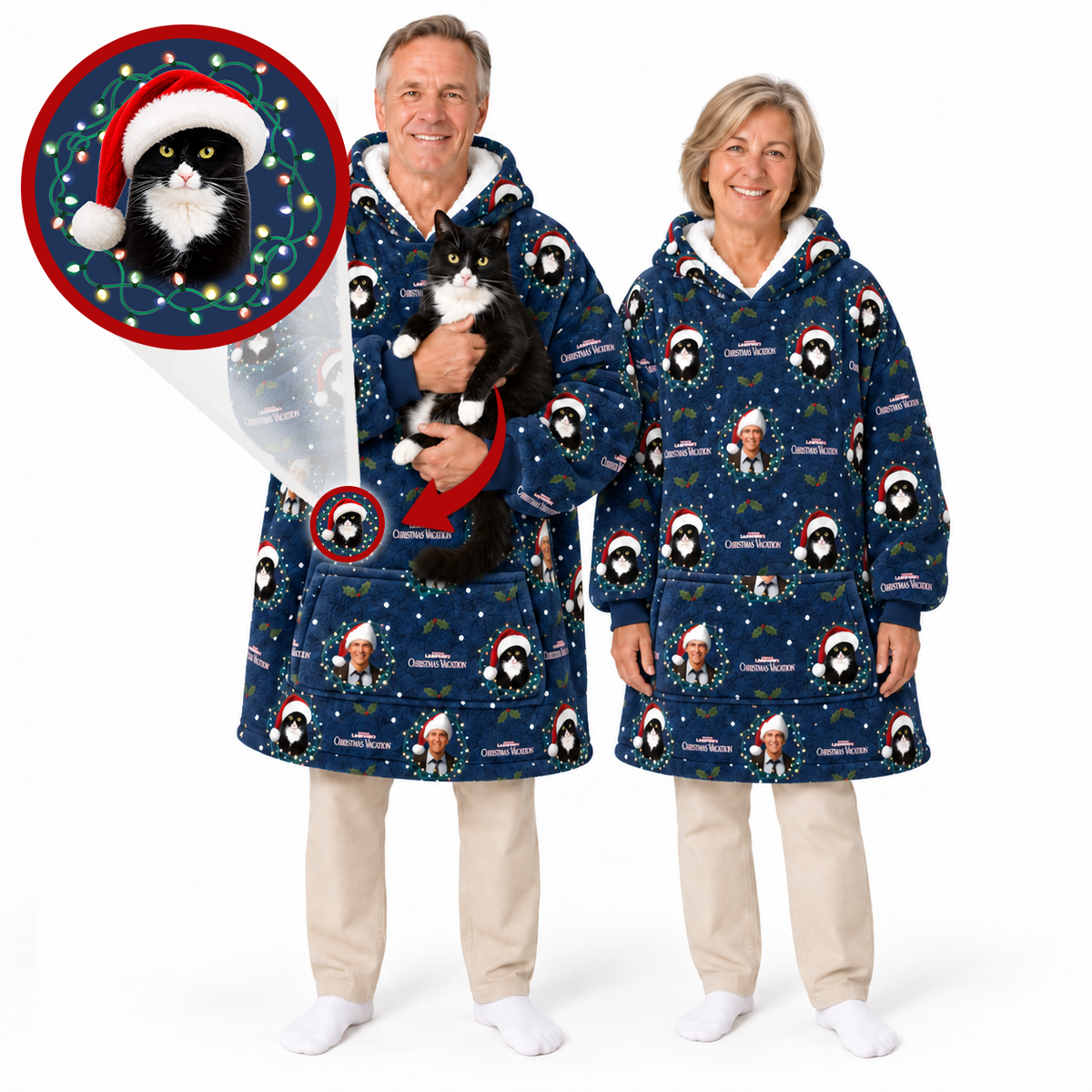 Two adults wearing matching navy blue hooded pajama robes with a festive cat print, standing against a white studio background. One adult is holding a black-and-white cat, and a circular inset at the top left shows a close-up of the robe's printed design with a cat wearing a Santa hat.