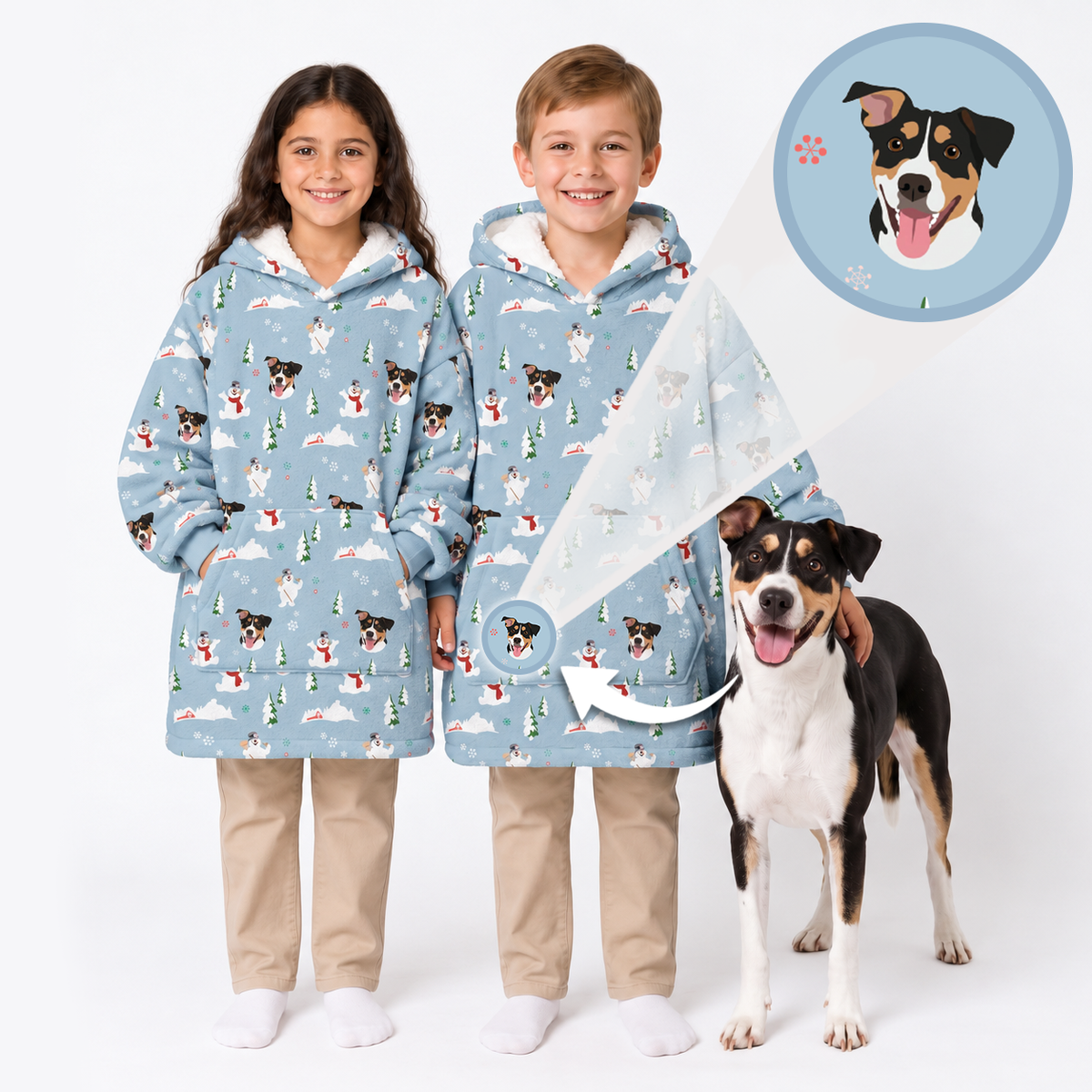 Two smiling children wearing matching light blue personalized winter hoodies featuring snowmen and custom dog illustrations, standing beside a black, brown, and white dog, with an inset highlighting the pet artwork.