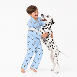 Child wearing a Sky Blue Dalmatian-print pajama set hugging a Dalmatian standing on its back legs.