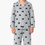 Child wearing gray pajamas with black cat patterns on a white background