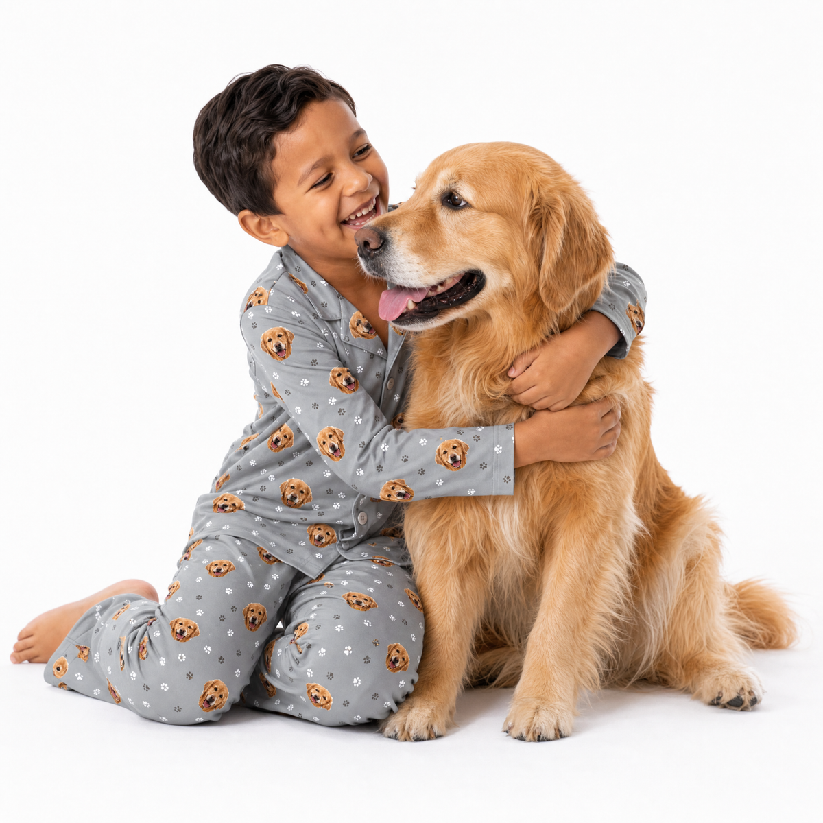 Child in pajamas with a golden retriever on a white background