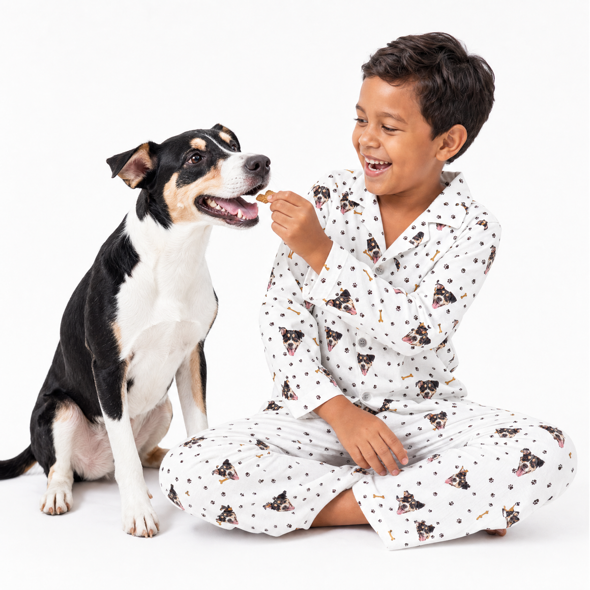 Child in a white pajama set sitting next to a dog on a white background
