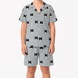 Child wearing a gray pajama set with black cat prints on a white background