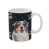 Close up of a black ceramic mug with paws and the phrase "I Love Dad", featuring a smiling, multicolored Australian Shepherd [ILoveDadHandIllustration]