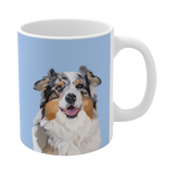 A clean product shot of a blue ceramic mug featuring a smiling, multicolored Australian Shepherd [SkyBlueHandIllustration]